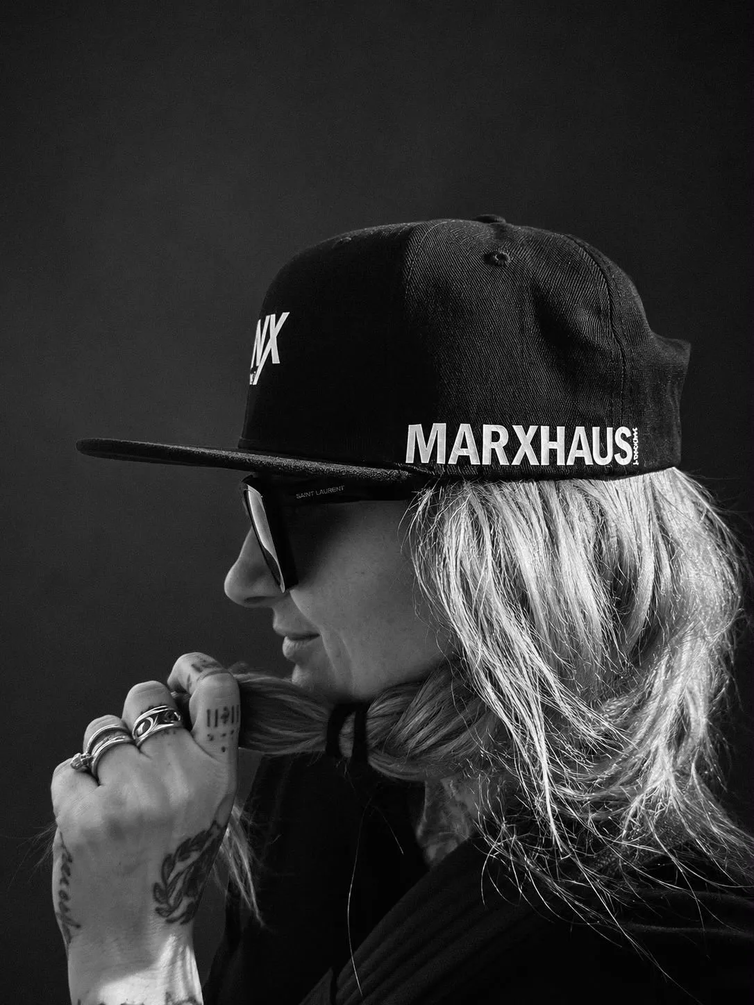 Black and white side profile of the same person wearing the cap, MARXHAUS printed along the side panel above the flat brim