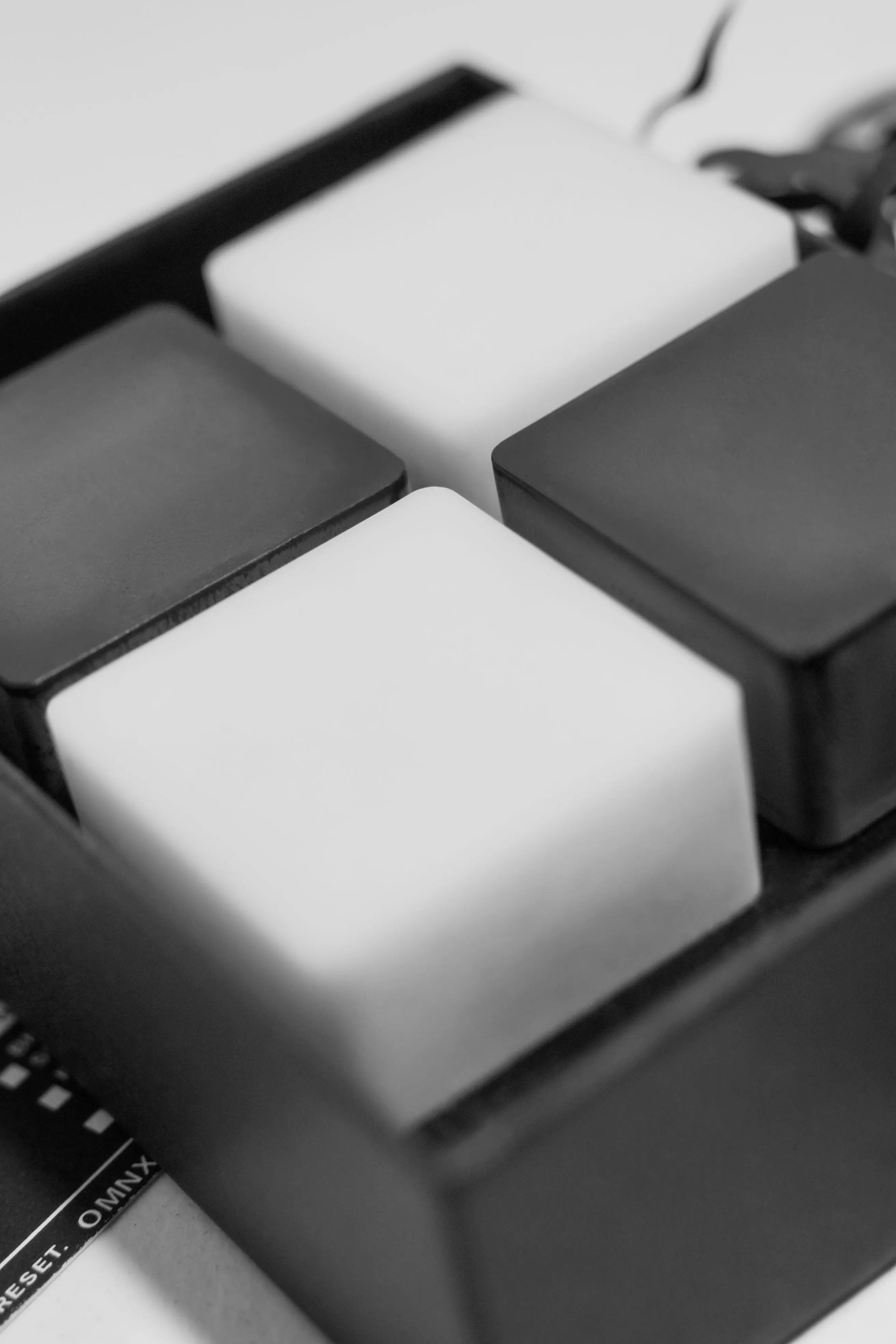 The four Drift squares close up in their tray, two white and two black set as a chequerboard