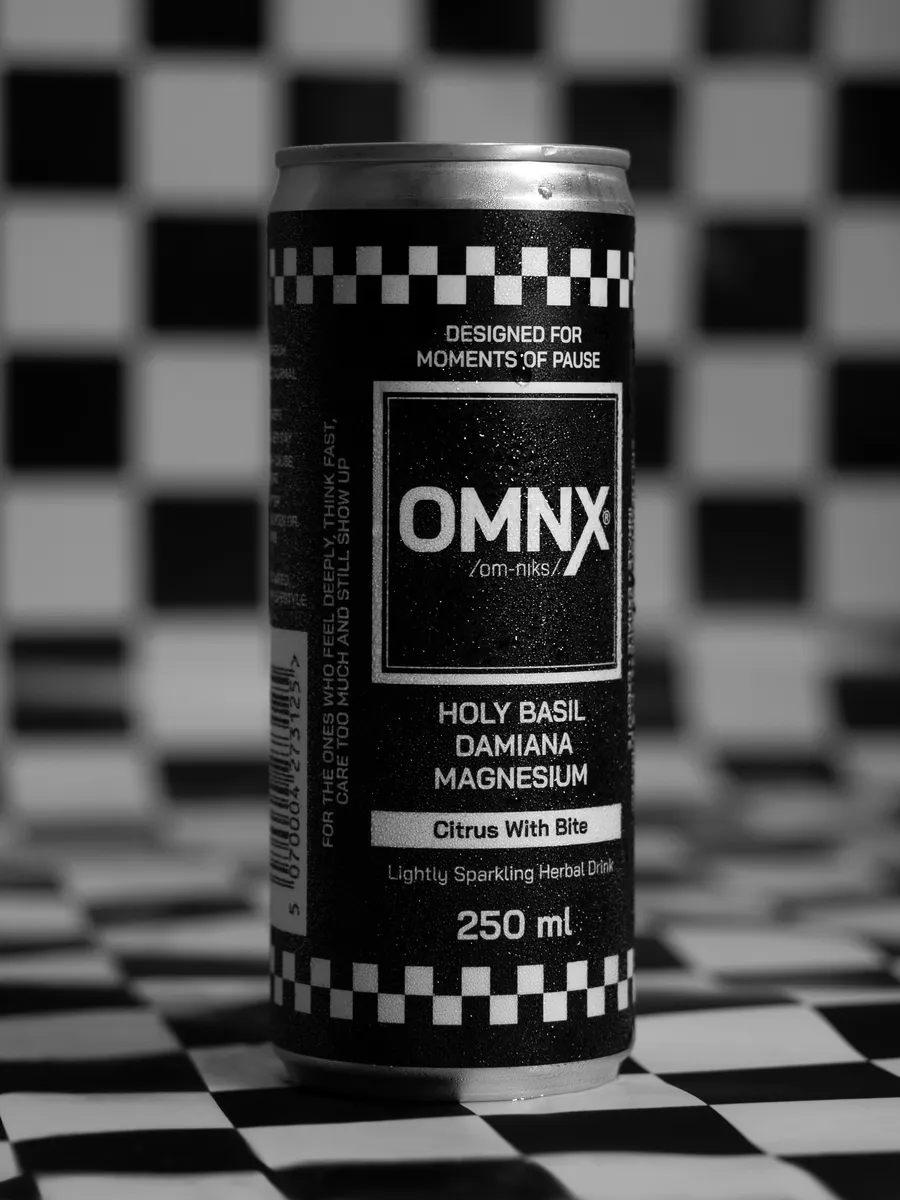 OMNX can standing on a black and white chequered floor